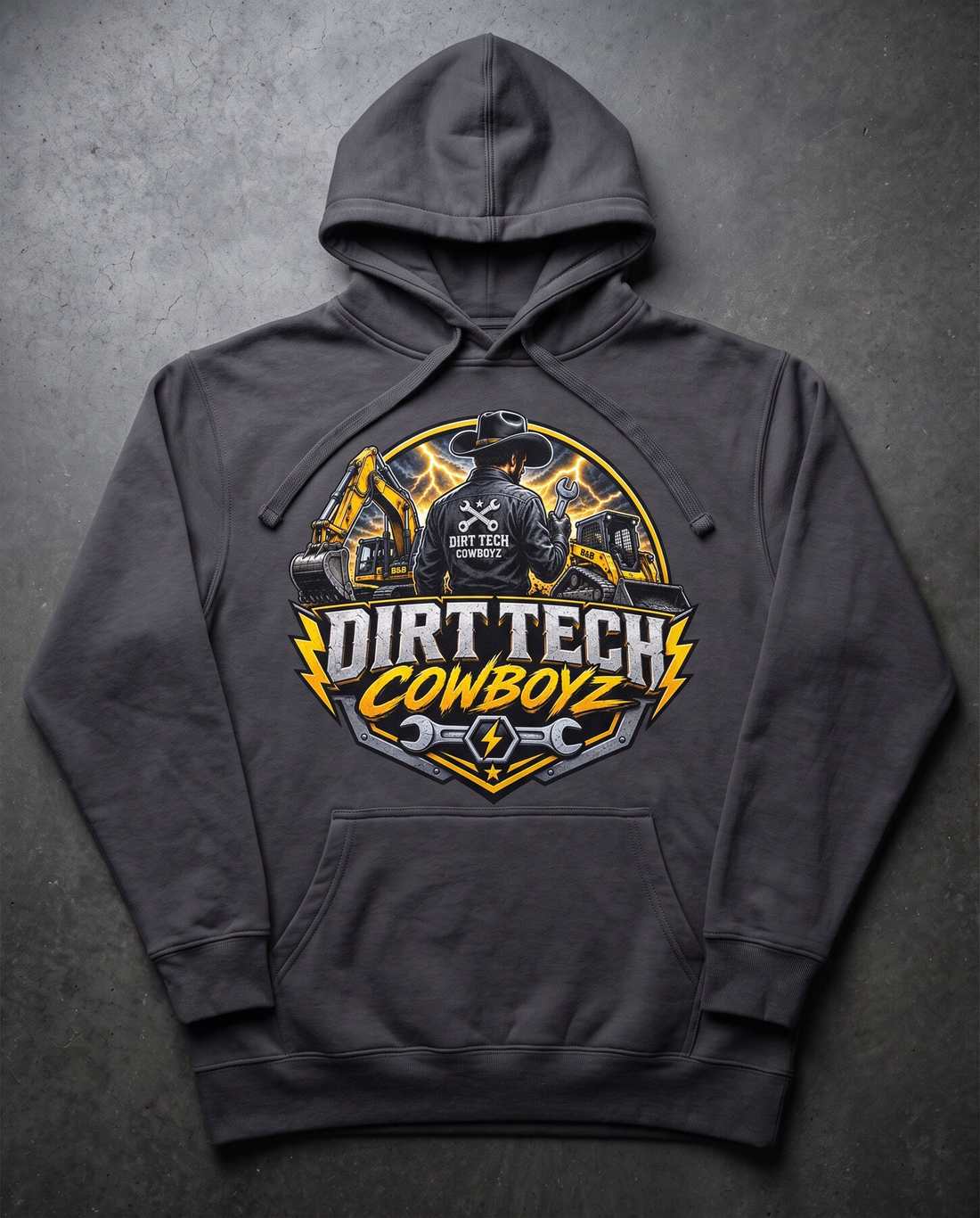 Charcoal grey Dirt Tech Cowboys pullover hoodie laid flat on dark concrete.