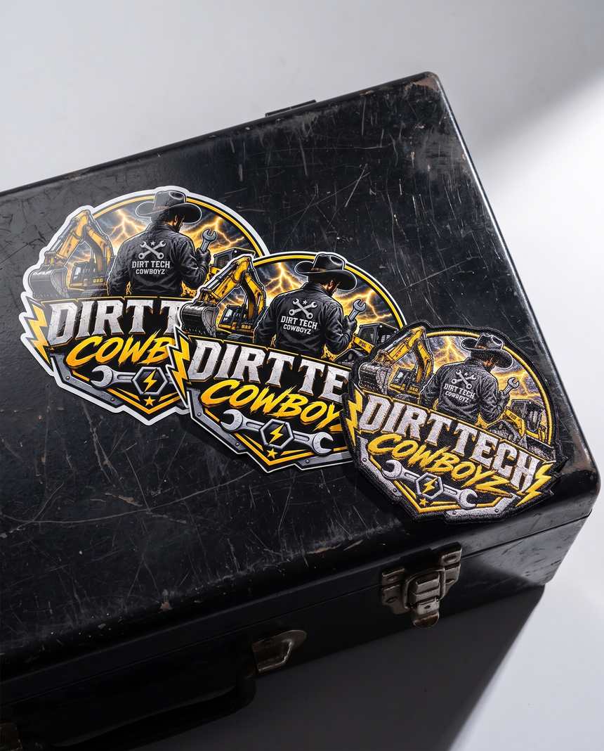 Dirt Tech Cowboys die cut vinyl stickers and an embroidered patch on a black toolbox lid.